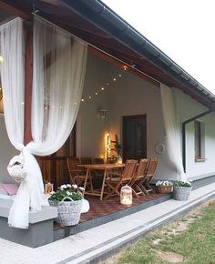 an outside patio with chairs and tables covered in white drapes