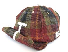 Wearing the Makshy eight-panel red check Harris Tweed baseball cap, you will exude an undeniable sense of elegance and self-composure. The cap's fusion of classic and modern elements radiates sophistication, elevating your overall style. With its comfortable fit and versatile design, you can enjoy satisfaction and ease, knowing you've chosen an accessory that complements your individual taste while providing practical benefits for various occasions. Fashion isn't always about pushing boundaries; sometimes, it's about embracing classic elegance, as exemplified by this Harris Tweed cap. Effortlessly adjust the visor or roll it up and secure it with the velcro motif for added versatility. Ideal for those on-the-go or packing for a trip, the cap's foldable and portable nature offers convenienc Tweed Cap, Tweed Hat, Red Panels, Hat Base, Large Hats, Unique Hats, Visor Cap, Harris Tweed, Custom Hats