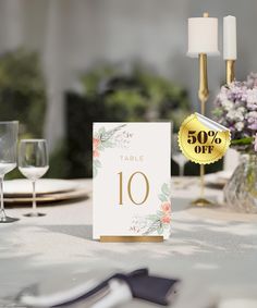 the table is set with white linens and place cards for an elegant wedding reception