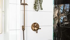 a shower head and hand shower faucet in a bathroom with white tile walls