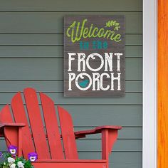 a red chair sitting in front of a welcome to the front porch sign on a house