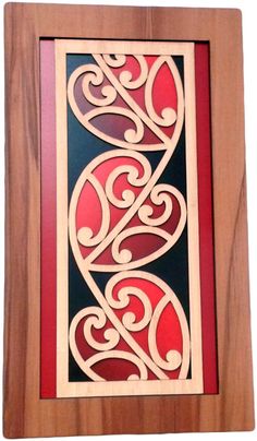 a wooden frame with an intricate design on the front and back side, in red and black