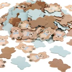 a pile of brown and blue teddy bears on top of a white surface with holes in the middle