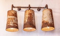 three rusty lights are hanging on the wall