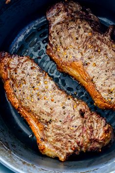 two steaks are cooking in a pan on the stove