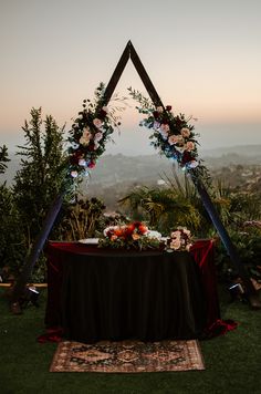 an outdoor ceremony setup with flowers and greenery