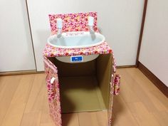 a dollhouse bathroom with sink and toilet in the corner on the hardwood flooring