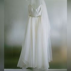 a white wedding dress hanging on a hanger