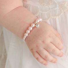 Pink Luster Pearl Bracelet with Silver Heart Charm | Baby Beau & Belle A sweet and simple gift for your baby girl. Arrives in an elegant laced lined metal box for a cute presentation. Also makes a perfect first birthday or flower girl gift! ~ Pink luster pearls ~ Sterling silver heart charm ~ Includes - Bracelet and gift tin ~ Handmade in the USA SIZING ~ 0-6 Months - Up to 4.25" ~ 6-12 Months - Up to 5" **Please note that the bracelet should be worn under adult supervision and contains small pa Christening Gifts For Boys, Pink Pearl Bracelet, Baby Heart, Simple Gift, Baby Bracelet, Baby Jewelry, Flower Girl Gifts, Gifts Baby, Tin Gifts