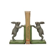 two bookends made to look like rabbits holding each other's hands and standing on their hind legs