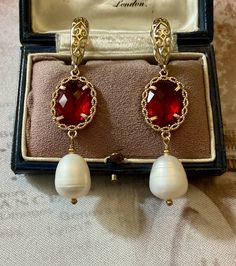 VICTORIAN VINTAGE LONG VERY BEAUTIFUL GOLD PLATED EARRINGS DECORATED WITH A VERY IMPOSING GENUINE PEARL AND A BEAUTIFUL FACETED RUBY COLOURED STONE. REMARKABLE WORK, ELEGANT VICTORIAN DESIGN, SUBLIME GENUINE PEARL, BEAUTIFUL EFFECT. ABSOLUTELY HUGE GENUINE WHITE PEARL: 13 X 10: mm. BEAUTIFUL RUBY COLOR STONE: 14 X 10 mm. DIMENSIONS: 55 x 14 mm. WEIGHT: 9.3 gr. IN VERY GOOD SHAPE. BOX NOT INCLUDED. Ruby And Pearl Earrings, Red Victorian Earrings As Gift, Victorian Red Earrings As Gift, Elegant Red Pearl Earrings For Anniversary, Red Drop Pearl Earrings For Gift, Red Pearl Earrings For Formal Occasions, Red Pearl Earrings For Party, Red Pearl Drop Earrings For Formal Occasions, Red Pearl Drop Earrings For Wedding