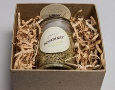 an open box containing a jar of rosemary