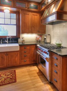 a kitchen with wooden cabinets and an oven in the center, sink on the far side