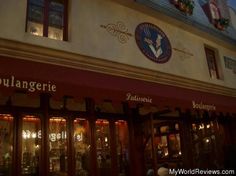 the outside of a restaurant with red awnings on it's roof and windows