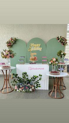 the dessert table is decorated with flowers and greenery