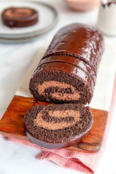 a chocolate roll is cut in half on a cutting board