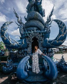 a woman standing in front of a blue sculpture