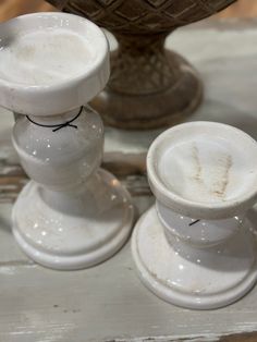 two white vases sitting next to each other on a table