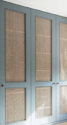 an empty room with blue doors and wicker panels