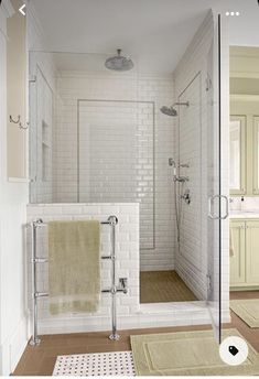 a bathroom with a shower, toilet and rugs on the floor