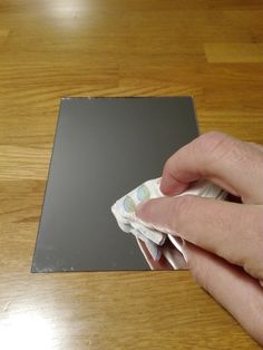 a person is holding something in their hand on top of a piece of paper that has been folded