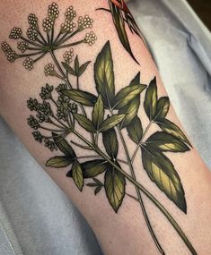 a woman's arm with flowers and leaves on it