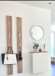 a white bathroom with wooden accents and mirrors on the wall, along with a sink