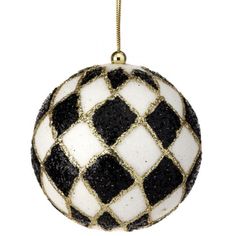 a black and white ornament hanging from a gold chain