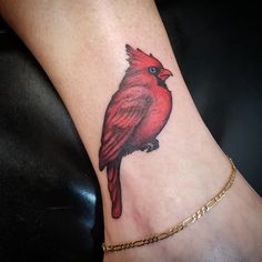 a red bird tattoo on the ankle