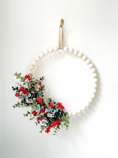 a wreath with red and white flowers hanging on a wall