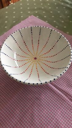 a white bowl sitting on top of a pink and white checkered tablecloth covered table