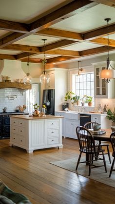 an open kitchen and dining room with wood floors, white cabinets and wooden beams on the ceiling