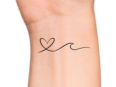 a small wrist tattoo with a heart on it