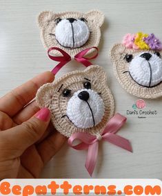 three crocheted teddy bears with pink bows on their heads, one wearing a flower in its hair