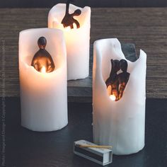 three candles that have been made to look like people in the shape of human figures