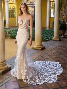 a woman in a wedding dress standing on a patio with columns and arches behind her