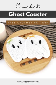 two crocheted ghost coasters sitting on top of a cutting board next to a candle