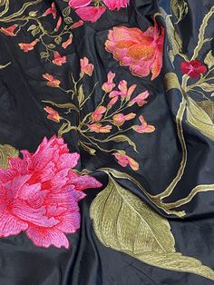 a black fabric with pink flowers and green leaves on the top right side is shown