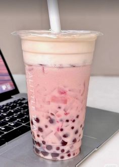 a drink sitting on top of a laptop computer