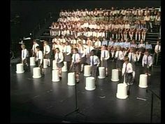 a group of people standing on top of white buckets in front of a stage