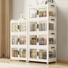 a white bookcase filled with lots of books next to a window in a room