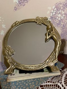 a mirror sitting on top of a table next to a doily