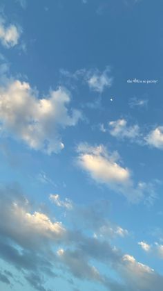 the plane is flying high in the blue sky with some clouds above it and an airplane on the right side