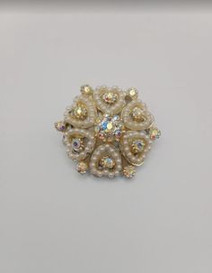 A beautiful Australian Opal brooch, perfect for elevating an evening outfit, with the endless and multicoloured reflection of the opal stones. White Brooch Jewelry For Evening, White Evening Jewelry With Brooch, Victorian Jeweled Wedding Brooches, Victorian Jeweled Brooches For Wedding, Ornate Wedding Brooches With Jewels, Vintage White Brooches For Evening, Victorian Jeweled Brooches For Party, Elegant Round Brooches With Rhinestones, Elegant Round Rhinestone Brooches