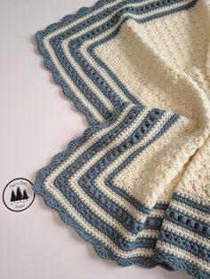 a blue and white crocheted blanket sitting on top of a table