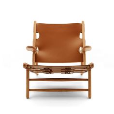 a brown leather chair sitting on top of a white floor next to a wooden frame