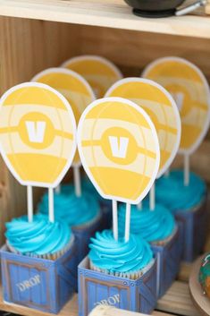 cupcakes with yellow and blue frosting are on display