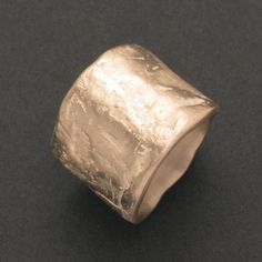 This silver ring with a width of 0.47 inch, 12 mm has an uneven surface, which impressively emphasizes the grandeur and value of the silver material. The individually designed structure of the silver ring makes it a very special piece of jewellery, which is particularly suitable for wearing on the middle finger. By tapering the inside of the rail, the ring feels pleasant when worn. Dimensions: Width of the ring on the front: 0.71 inch, 18 mm Width of the ring on the palm side: 0.47 inch, 12 mm Silver Wide Band Ring Hand Cast, Silver Wide Band Hand Cast Ring, Hand Cast Silver Wide Band Ring, Hand Cast Sterling Silver Wide Band Ring, Hand Cast Wide Band Silver Sterling Ring, Silver Concave Wide Band Ring For Anniversary, Unique Silver Engraved Wide Band Ring, Wide Band Silver Hammered Jewelry, Silver Hammered Signet Ring As Gift