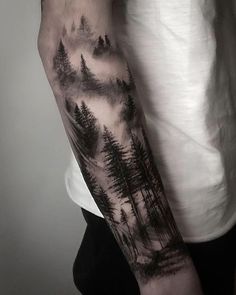 a man with a forest tattoo on his arm