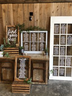 the reception table is set up with wooden crates and greenery on it, along with seating signs